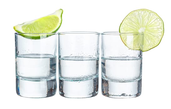 Three tequila shots with lime isolated on white background