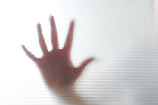 Diffused silhouette of female hands through plastic