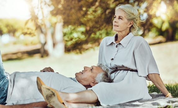 Retirement, love and relax with a senior couple outdoor in nature for a picnic on a green field of grass together. Happy, smile and date with a mature man and woman bonding outside for romance.