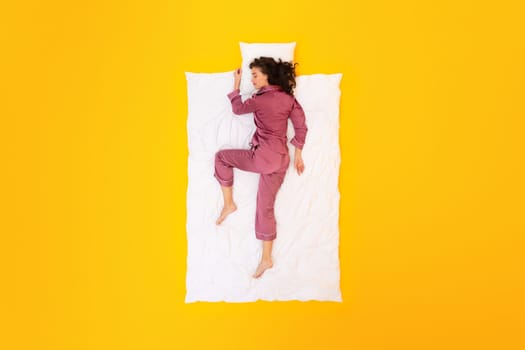 Full Length Of Woman Napping in Comfortable Sleepwear, Yellow Background
