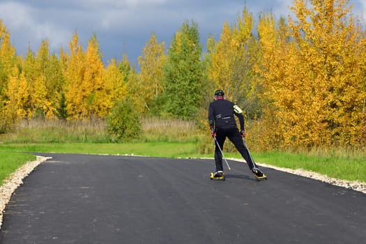 Moscow, Russia - 29 Sept. 2021. A man on roller skis rides along a sports track in Zelenograd