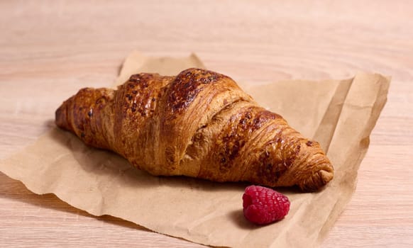 Baked crispy croissant on a wooden board, breakfast