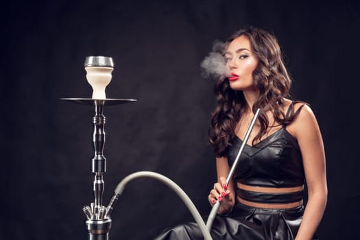 girl smokes hookah / beautiful glamorous girl in black dress smokes a hookah