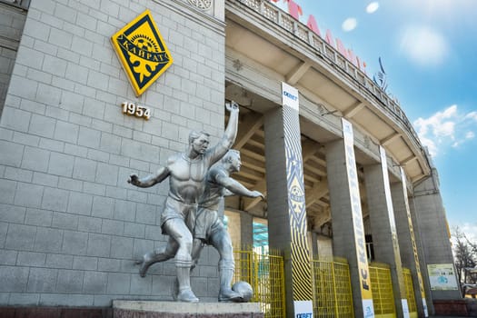 Sculptures of football players near the central stadium of Almaty with the symbols of FC Kairat