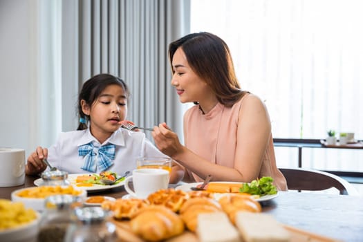 Mom and little preschooler have fun eating meal together