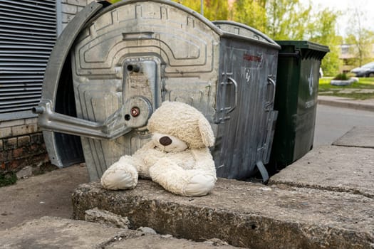 abandoned teddy bear near the dumpsters. concept of betrayal