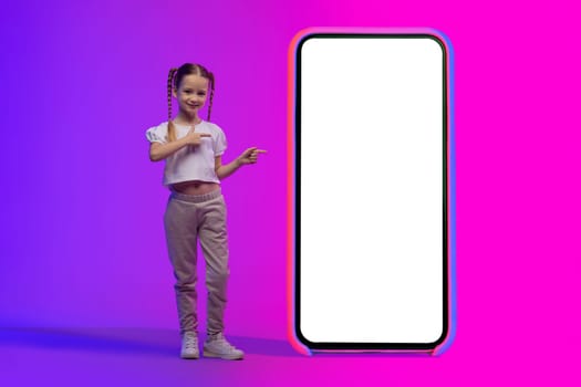Connected World. Little girl pointing at huge phone with mockup