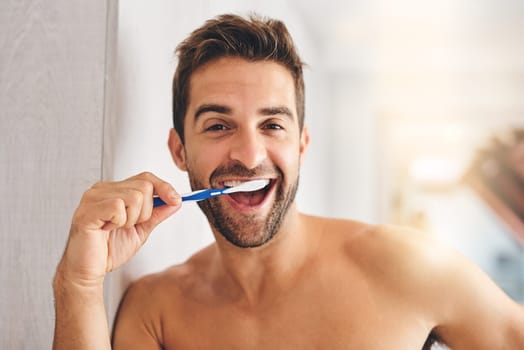 Portrait, toothbrush and happy man brushing teeth in morning for dental wellness, healthy habit and gums. Face of guy cleaning mouth for fresh breath, oral hygiene and routine in bathroom at home