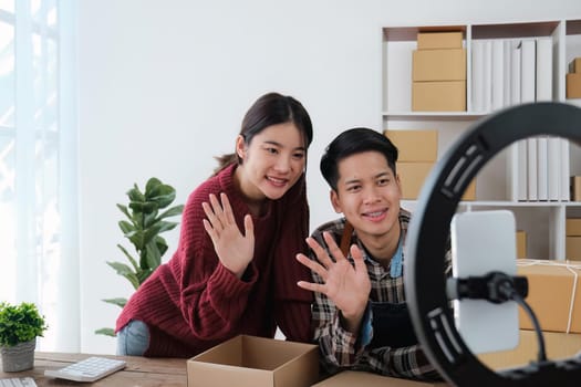 young couple mobile phone recording live streaming in online social media selling products by couple, doing freelance, own business or entrepreneur at home. E-commerce, shopping concept
