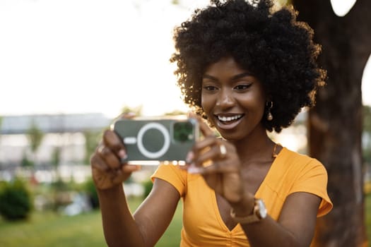 Portrait of a young afro american woman taking a selfie outdoor