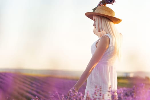 Back view of female in dress and hat standing in lavender field