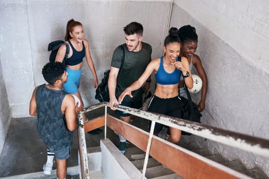Soccer, group and fitness, walking and stairs for cardio, diversity and friends exercise together in healthy and active lifestyle motivation. Young, men and women happy, athlete and sports training