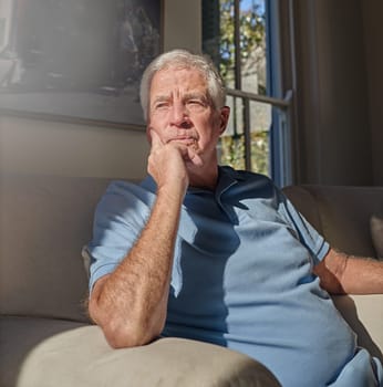 Lonely senior man thinking in home, couch and lounge about future anxiety, remember memory and alzheimer. Retirement, elderly male and nostalgia memories on sofa, depression and dementia in isolation