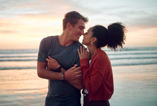 Love, beach and couple kiss at sunset, happy and bonding on their summer vacation in Florida. Travel, freedom and romance with man and woman enjoying a walk along the ocean and showing affection.
