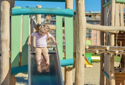 Girl of 3 years old sliding outdoor Playground