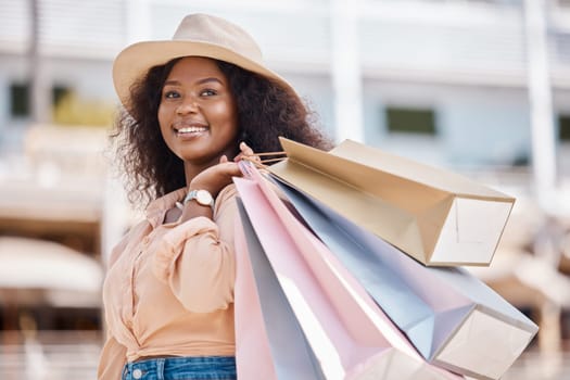 Black woman, retail shopping bag and city customer buying sales, luxury fashion brands and summer market product choice from Brazil mall store. Style, happy and rich young consumer thinking in street