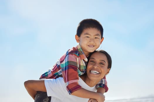 Mother, beach piggyback and child in portrait, interracial family bonding and outdoor vacation in sunshine. Happy family, asian boy and black woman for adoption, love and ride game on ocean holiday