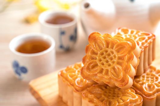 Mid-Autumn Festival holiday concept design of moon cake,mooncakes,tea set on bright wooden table and serving plate with copy space, close up.