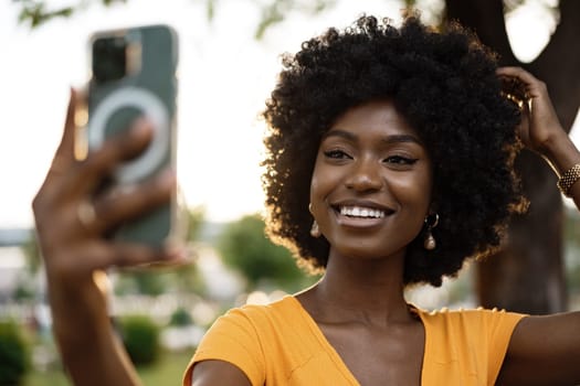 Portrait of a young afro american woman taking a selfie outdoor