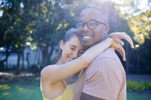 Summer, love and interracial with a couple bonding outdoor together in a park or natural garden. Nature, diversity and romance with a man and woman hugging while on a date outside in the countryside.