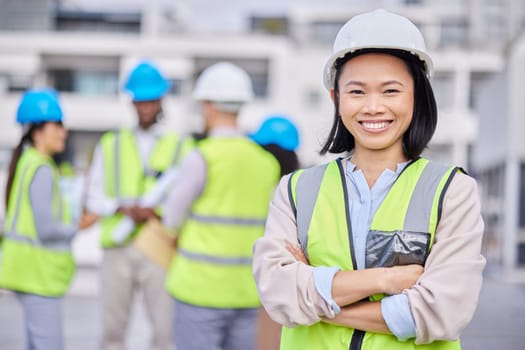 Portrait, Asian woman arms crossed and engineer outdoor, building and inspector with smile, new project and deadline. Face, female employee and manager with hard hat, vest and construction inspector