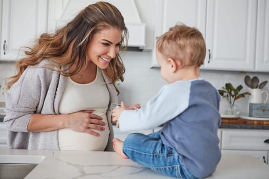 Its snack time. a pregnant woman and her son spending time together in the kitchen at home.