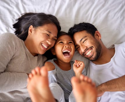 Bed, fun and happy family playing, wake up and happy from above, tickle and laughing in their home. Bedroom, games and girl with parents, smile and laugh, relax and love in their house on the weekend