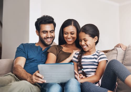 How modern families connect. a mother and father using a digital tablet with their daughter on the sofa at home