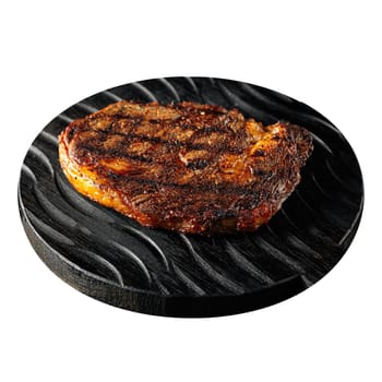 Isolated grilled steak on black serving board