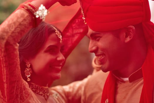 Wedding, romance and red veil with a couple together in celebration of love at a ceremony. Happy, marriage or islam with a hindu bride and groom getting married outdoor in tradition of their culture