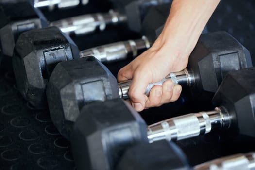 Closeup, hand and gym for exercise with weightlifting, dumbbell and muscle development. Training, sports and workout at fitness center for health, wellness and physical strength in Los Angeles