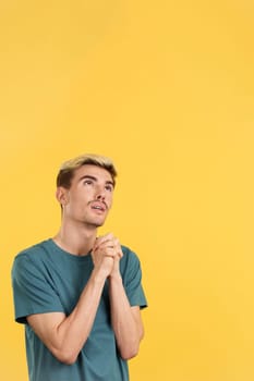 Gay man looking up while praying with folded hands