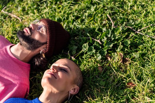 man and woman enjoying lazy day lying in the lawn