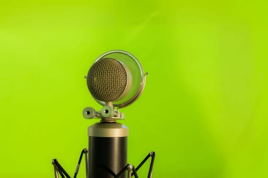 Vocal condenser microphone with wind screen isolated on green background