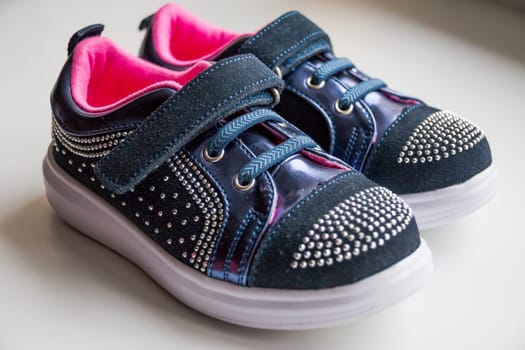 Baby boots, luxury sneakers, sports shoes, boots for girls. Kids trendy footwear with rhinestone decoration. pretty pair of casual baby shoes with a velcro fastening strap.Children's shoes. Moccasins. Leather