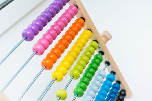 Preschooler learns to count. abacus toy.child having fun indoors at home, kindergarten or day care centre. Educational concept.Traditional counts,abacus with colorful wooden beads. early math skills
