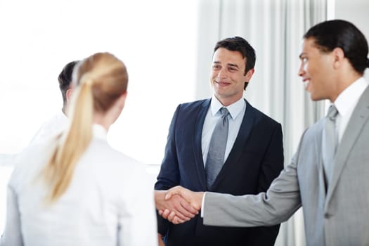 Doing some client liaising. A positive businessman shaking hands with a coworker during a meeting.