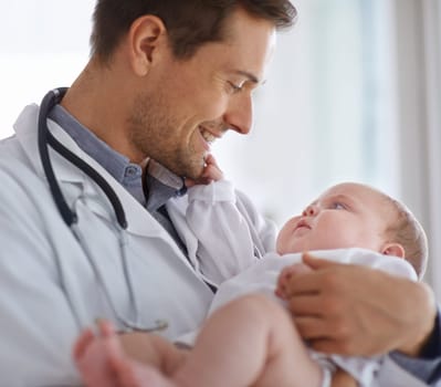 Happy male doctor, pediatrician and holding baby for hospital assessment, medical support and growth. Pediatrics, physician and carrying newborn kid in clinic, healthcare service and helping children.