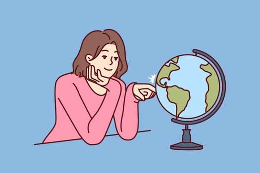 Woman dreams of traveling world looking at globe with planet earth and continents