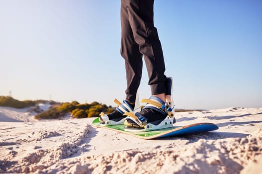Sandboard, sports and athlete in the desert sand with hills for exercise, competition or training. Fitness, travel and man on a board in a dune for a workout while on vacation or adventure in Dubai