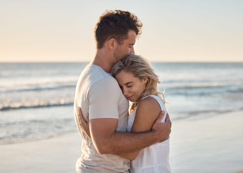 Dating, love and couple hug at the beach, happy after engagement on holiday, summer vacation and honeymoon. Nature, romance and happy man and woman embracing, hugging and bonding by ocean on weekend.