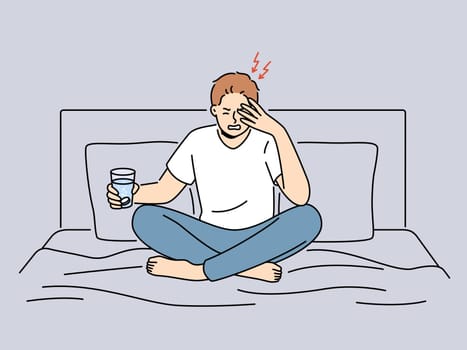 Unhealthy man sit on bed suffer from headache