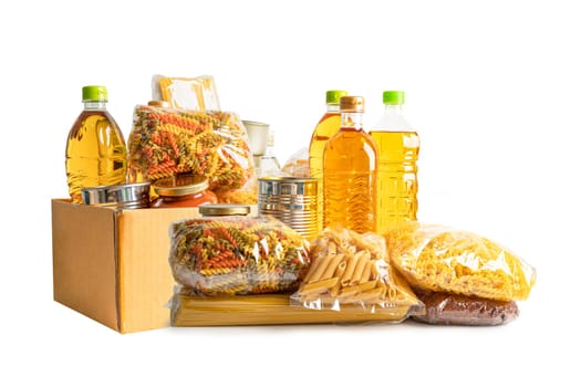 Foodstuff for donation isolated on white background, storage and delivery. Various food, pasta, cooking oil and canned food in cardboard box.
