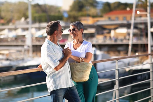 Happy Mature Spouses Embracing At Marina Backdrop With Luxury Yachts