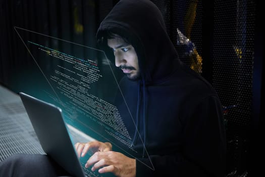Cyber security, coding and hacker in server room with hologram, laptop in data center and stealing sensitive digital information. Technology, software and man hacking in database to update ransomware