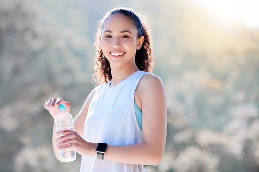 Happy woman, portrait smile and water in fitness for sustainability, hydration or break from running in nature. Fit, active and sporty female person or runner smiling with bottle for thirst in run