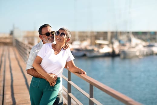 Joyful Mature Spouses Hugging Standing Near Yachts At Sea Marina