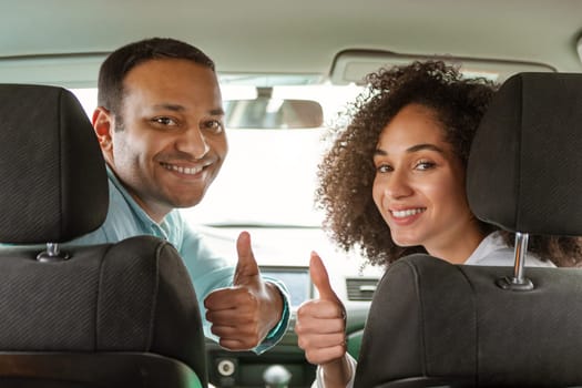 Cheerful Arabic Car Owners Couple Gesturing Thumbs Up In Vehicle