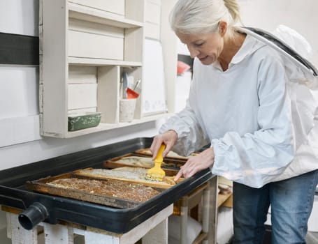 Beekeeper woman, uncapping fork and honey production in apiary workshop, factory or warehouse. Bee farmer, honeycomb and beeswax in agriculture workspace, farming and organic process in Los Angeles