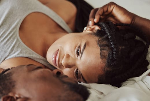 Black couple, love and bedroom romance while happy and intimate on a bed at home, apartment or hotel to relax. Face of a young man and woman in a happy marriage with commitment, trust and care.